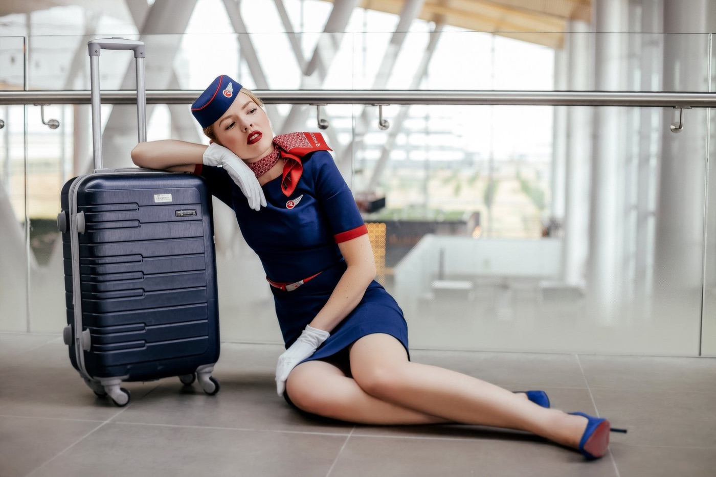 woman sitting on the floor beside black luggage